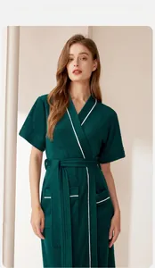 Dettaglio dell'accappatoio in spugna verde scuro con bordo bianco e tasca in vita