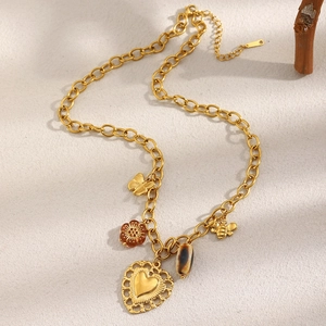 Detail of 18K gold O-chain necklace featuring vintage heart, butterfly and bee charms