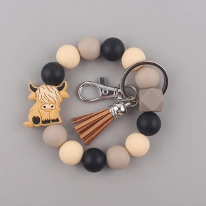 Detailed view of highland cow silicone bead keychain with brown tassel and metal clasp
