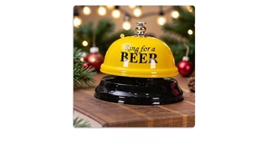 Detail of a yellow metal call bell with Ring for a BEER text on a festive table