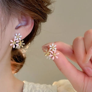 Detailed view of floral earrings with three small flowers and a dangling square zircon