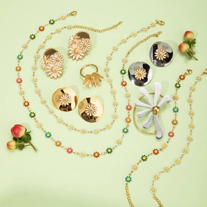 Flat lay of 18k gold stainless steel daisy necklace set with colorful enamel charms