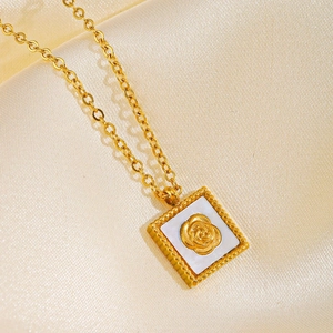 Golden necklace with square white shell pendant and carved rose on gold silk background