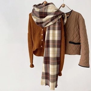 Close-up of classic earthy-toned plaid scarf with caramel knit cardigan for winter