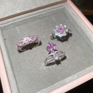Close-up of three pink zircon rings in luxury velvet box showing sparkling gems