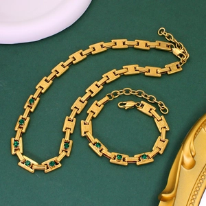 Detailed macro view of 18K gold plated stainless steel necklace and bracelet set with green gems