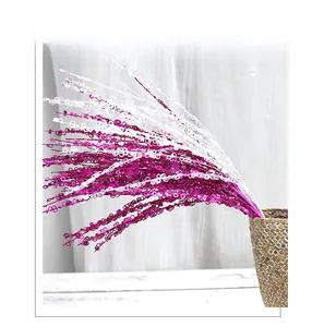 Sparkling purple and white sequin branches arranged in a woven basket for Christmas decor
