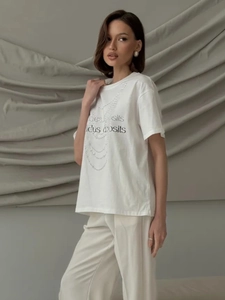 Detail of white cotton T-shirt featuring pearl necklace print and artistic lettering design