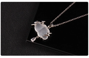Macro shot of cloud necklace with silver lightning accents and a sparkling raindrop charm