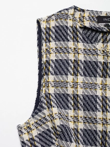 Détail macro de la texture du tissu en tweed bleu marine et jaune avec motif écossais