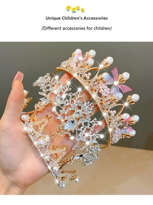 Detailed close-up of a silver rhinestone tiara and a golden pearl butterfly headband