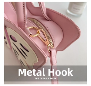 Detailed close-up of pink butterfly bag showing smooth zipper and gold hardware hooks