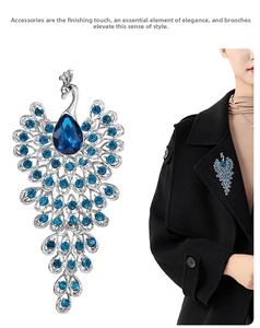 Close-up of elegant peacock brooch with blue teardrop crystal and silver plating