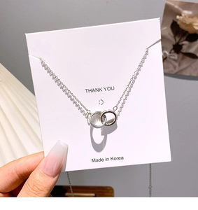 Macro view of silver interlocking double circle pendant with pavé cubic zirconia details