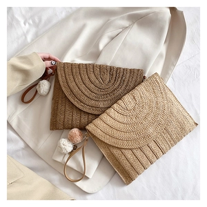 Handmade straw woven envelope clutches in two colors with pompom charms and wrist straps