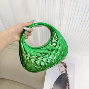 Macro shot of candy-colored emerald green acrylic handbag with rhombus quilted pattern texture