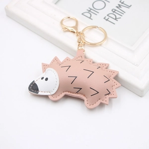 Pink PU leather hedgehog keychain with golden metal clasp and black V-pattern texture