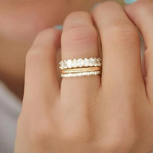 Dettaglio macro del set di tre anelli in oro 18 carati con pietre di zircone a pera