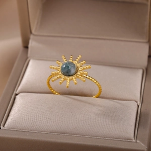Detail of golden sunburst ring with turquoise stone in brown velvet jewelry box