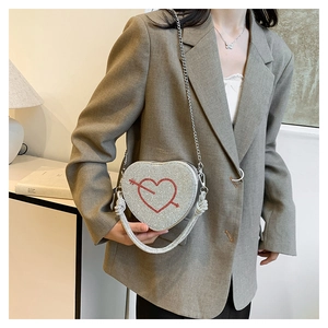 Dettaglio della borsa a cuore con strass argentati e decorazione a freccia rossa