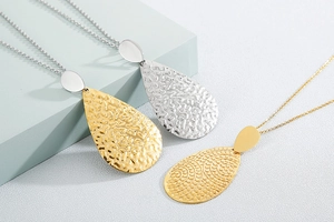 Macro detail of gold and silver teardrop pendants with hammered and spiral textures
