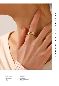 Detail of 18K gold-plated titanium steel leaf ring with brushed metal texture on finger