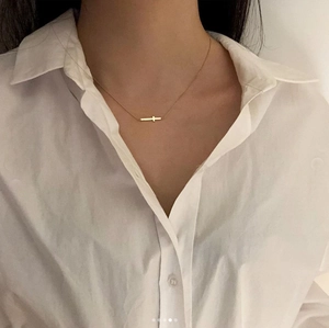 Minimalist golden cross pendant necklace shown on neck for a modern aesthetic jewelry look