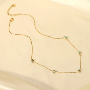 Detail of 18K gold plated stainless steel necklace with blue beads and evil eye charm