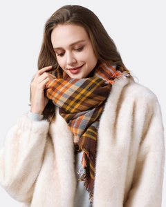 Close-up of classic orange and brown plaid scarf featuring soft fringe and woven texture