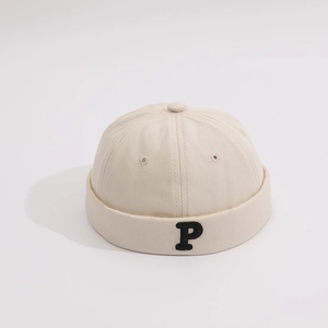 Detail of beige cotton pumpkin hat with black P letter embroidery and eyelet ventilation