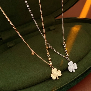 Macro view of gold and silver clover heart necklaces with 520 engraving in jewelry box