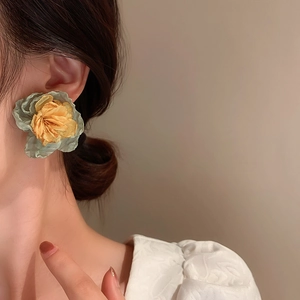 Detailed side view of 3D fabric flower earrings with green petals and yellow centers