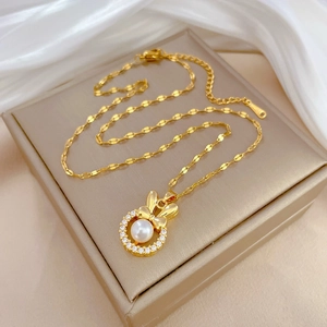 Elegant gold titanium necklace with a rabbit ear pearl pendant and sparkling zircons