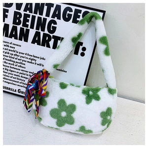 Detailed close-up of white plush handbag with green floral patterns and silk scarf decoration