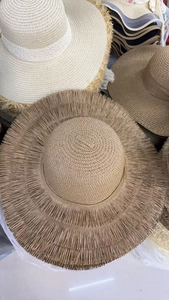 Detailed close-up of woven straw sun hats featuring frayed edges and flat top design
