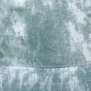 Detailed macro view of tie-dye fabric with twill texture and precision stitching