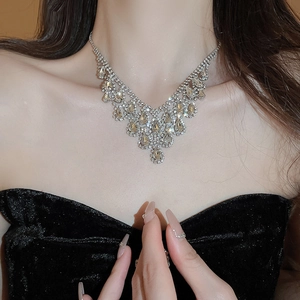 Close-up of sparkling rhinestone teardrop fringe necklace on model for evening dress