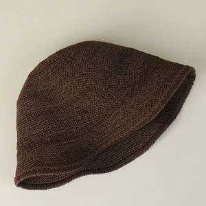 Détail d'un chapeau de soleil en tricot marron foncé avec texture épaisse et tissage