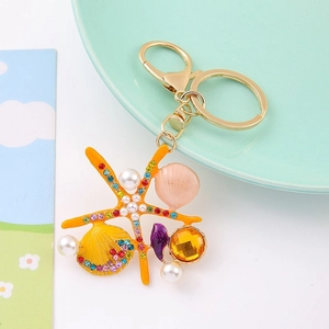 Detailed close-up of a gold keychain featuring colorful crystal starfish and sea shells