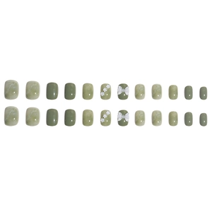 Short green press-on toenails with flower and bow accents in a refreshing marble design