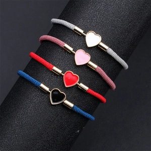 Detail of adjustable heart-shaped braided bracelets in four colors on black cylinder stand