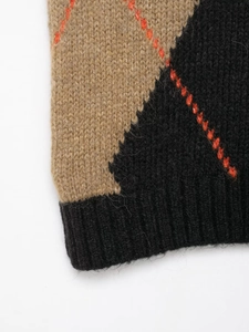 Detailed view of argyle knit pattern and ribbed hem on V-neck sweater vest