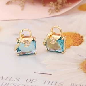 Macro view of blue gemstone handbag earrings with a sparkling crescent moon detail