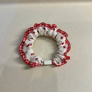 Macro detail of red plaid lace hair scrunchie with cute bear print and soft fabric texture