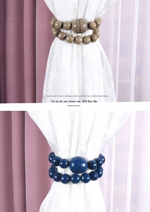 Detail of wooden beaded magnetic curtain tiebacks in blue and brown wood grain finish