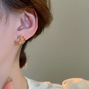 Close-up of vibrant crystal flower earrings featuring colorful petals and gold center