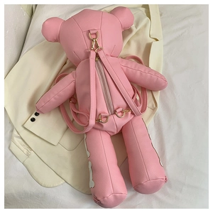 Detail view of pink PU leather bear backpack showing gold metal hardware and texture