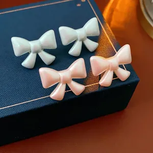 French vintage acrylic bow stud earrings with pearlescent finish in white and pink