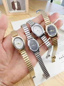 Close-up of four quartz watches with metal link straps in gold and silver finishes