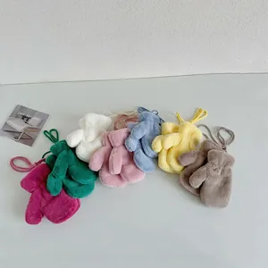 Flat lay of colorful plush winter mittens for children with matching hanging neck strings